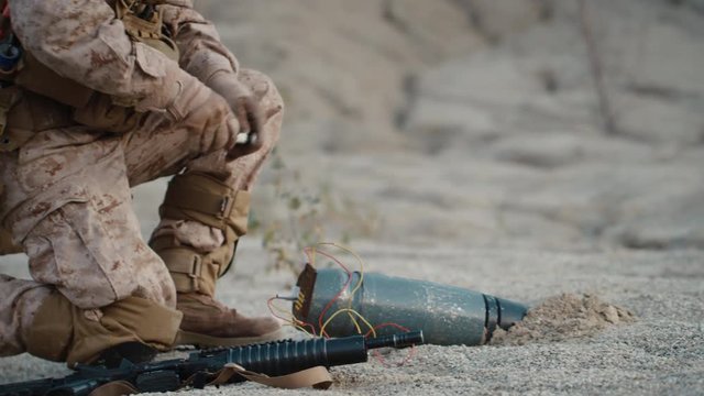 Soldier Defusing a Bomb by Cutting a Wire During Military Operation in Desert Environment
