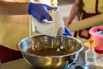 Hand makes the dough with mixer. Preparing cakes