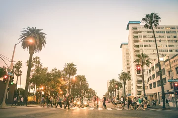 Locals en toeristen lopen op zebrapad en op Ocean Ave in Santa Monica na zonsondergang - drukke straten van de staat Los Angeles en Californië - Warme desat twilight kleurtinten met wazige mensen © Mirko Vitali