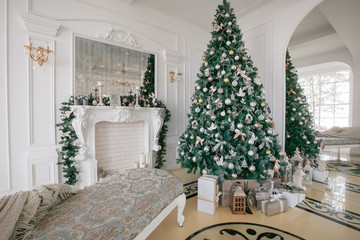 Christmas morning. classic luxury apartments with a white fireplace, decorated tree, bright sofa, large windows