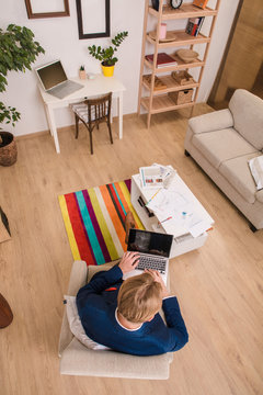 Top view of executive European businessman working on laptop computer at home. Thinkative man dreaming about new business enterprise.