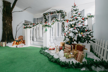 Christmas morning. classic luxury apartments with a white fireplace, decorated tree, bright sofa, large windows