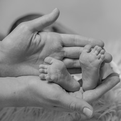 stopy dziecka w dłoniach matki