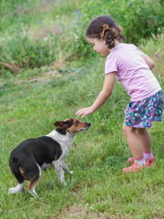 Girl playing with dog outdoors