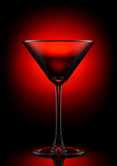 Empty martini glass on a color background.