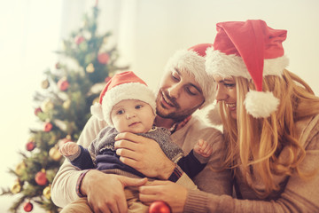 Happy family in the room with the Christmas tree