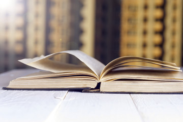 Open book on wood planks over abstract light background.