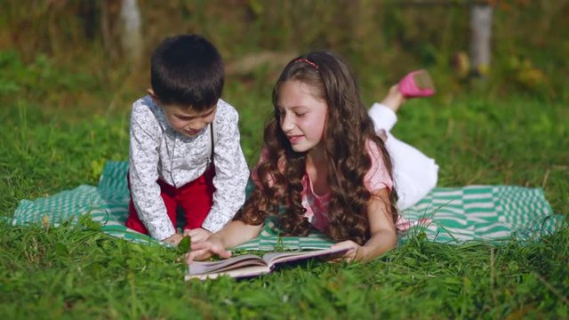 little children reading a book on nature