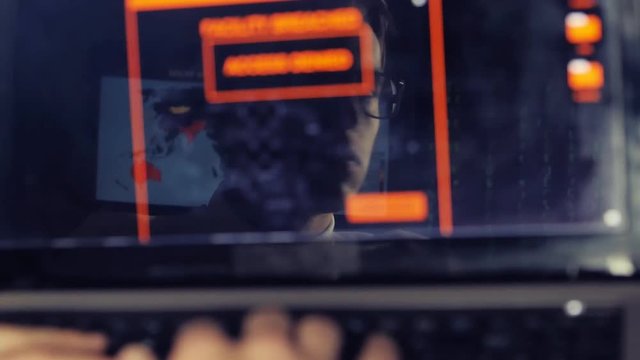 IT professional programmer in glasses is working on computer
