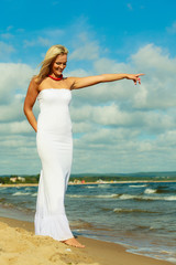Fototapeta na wymiar Beauty blonde woman pointing to sky.
