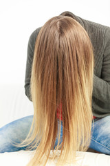 Girl hiding face behind hairs.