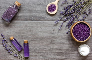 cosmetic creams with lavender flowers on black wooden table