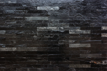 Black marble stone wall texture for background.