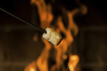Heating marshmallow at a fireplace