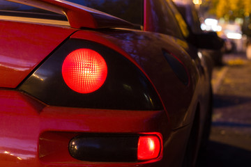 Red sports car glowing Back Lights at night. back view