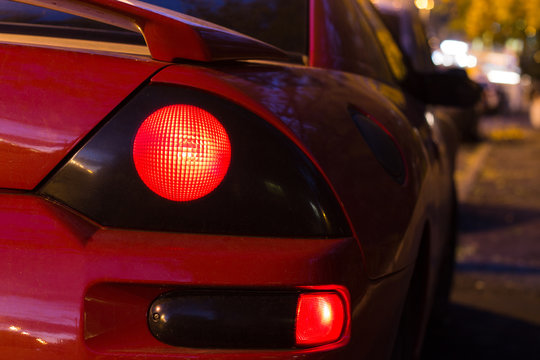 Red Sports Car Glowing Back Lights At Night. Back View