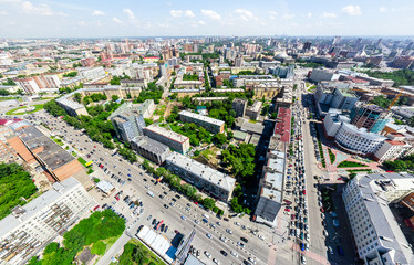 Fototapeta premium Aerial city view with crossroads and roads, houses, buildings, parks and parking lots, bridges. Urban landscape. Copter shot. Panoramic image.