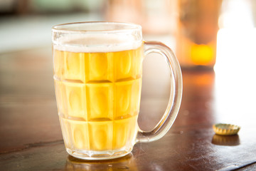 Glass of light beer on light.