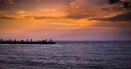 Fototapeta na wymiar Silhuettes of People Fishing at sunset