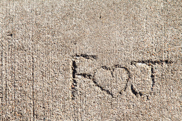 F heart J written in concrete