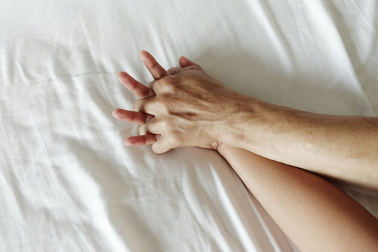 hand of women pulling white sheets in ecstasy, orgasm.