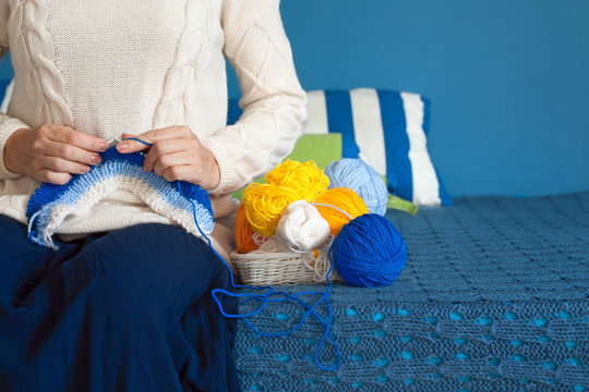 Woman in dark blue dress knit fabric of wool yarn.  
