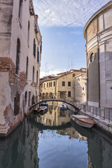 Fototapeta na wymiar Venice cityscape at early morning. Narrow canal among old colorful brick houses in Venice, Italy.
