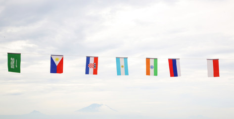 Many different flags against blue sky

