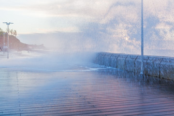 Big wave breaks over pier creating large splashes at Sunset. Melbourne, Australia