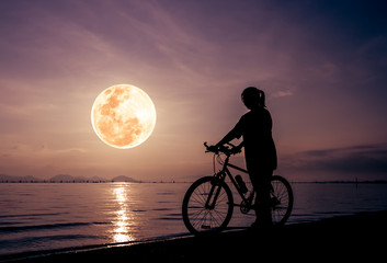 Silhouette of healthy biker-girl enjoying the view at seaside
