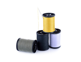 spool of thread and needle on white background