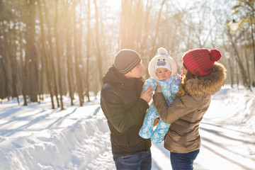 Fototapeta na wymiar parenthood, season and people concept - happy family with child in winter clothes outdoors