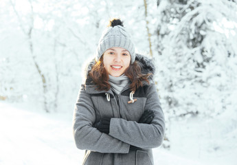 Fototapeta na wymiar Happy girl walking in a beautiful winter forest