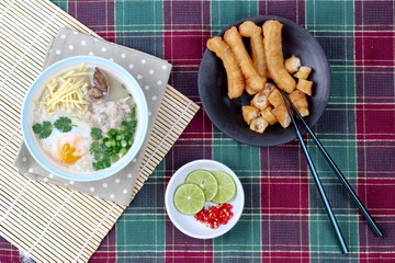 Rice porridge with mined pork and chicken lever served with side dish as Patongko (deep-fried dough stick) and spicy sour filling.
