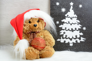 Teddy bear in santa hat near Christmas tree picture