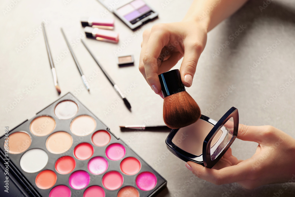 Wall mural female makeup artist hands with cosmetics at work