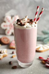 Delicious milkshake with Christmas decoration on grey textured background