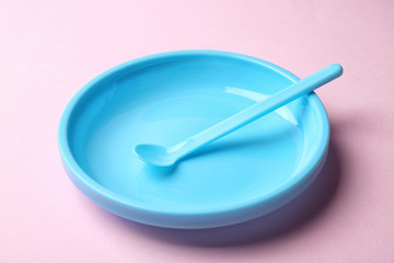 Bright baby tableware on pink background