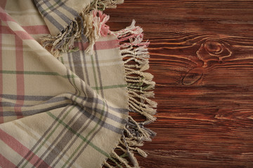 Cozy soft plaid on wooden background