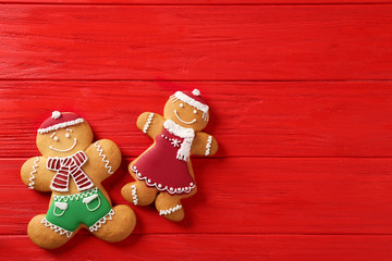 Tasty gingerbread cookies on red wooden table