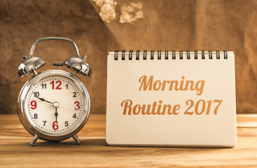 morning routine 2017 text on notebook with alarm clock on wood t