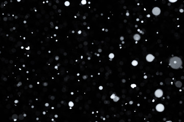 Falling snow on black background.