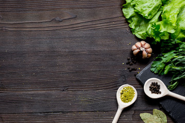 garlic, fresh salad and spices on wooden background top view