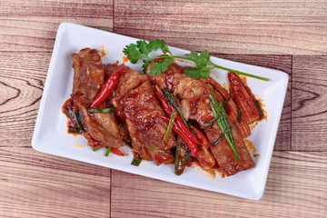 Fried pork spare ribs with grilled chili curry topped coriander for served. 
