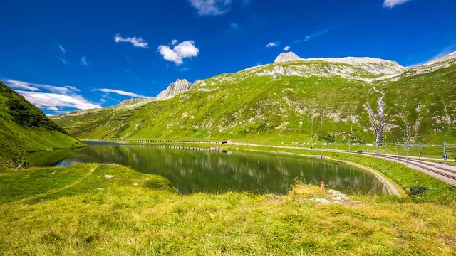 Rhaetian Railway train passing an Oberalp pass in summer through the line of Glacier Express from Zermatt to Sankt Moritz, Switzerland, UNESCO World Heritage Site, Europe

