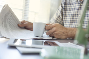 Man reading newspaper on table