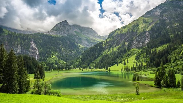 Dramatic 4K Timelapse of Lauenensee ( lake Lauenen) with waterfall and Swiss Alps in the background near Gstaad, canton Bern, Switzerland