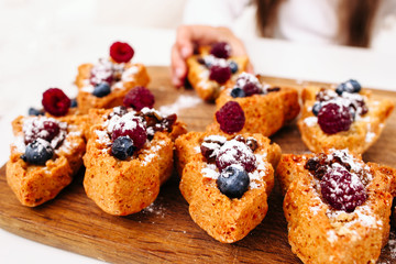 Close-up of sweet cakes with berries. Confectionery, homemade bakery with fresh fruits, pastry cooking concept