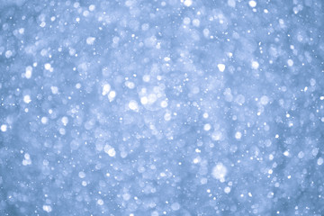 Abstract Blue Christmas Background with Real Snow. Blurred Snowflakes.