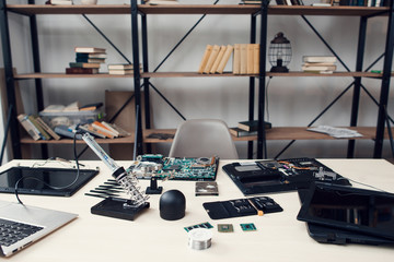 Electronic repair shop, workplace of engineer repairing technology. Table with necessary tools and...